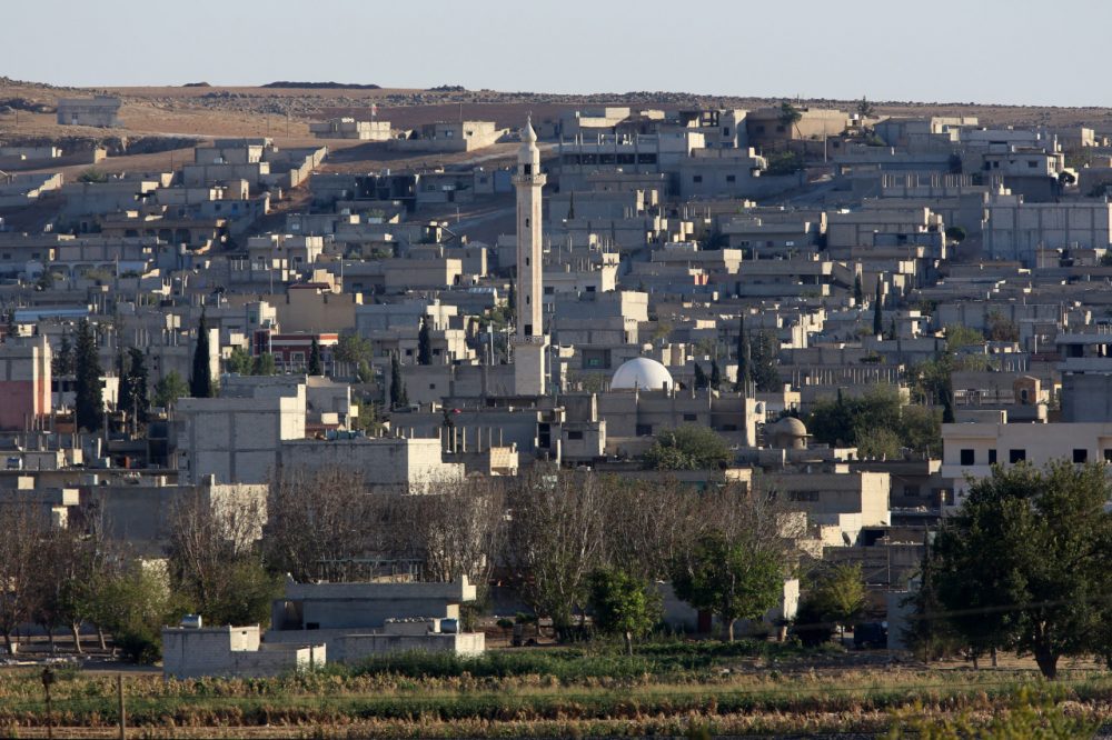 The city center of Syrian Kurdish town of Kobani seen from the Turkish side of border as thousands of new Syrian refugees from Kobani arrive at the Turkey-Syria border near Suruc, Turkey, Wednesday, Oct. 1, 2014. U.S.-led coalition airstrikes targeted Islamic State fighters pressing their offensive against a Kurdish town near the Syrian-Turkish border on Tuesday in an attempt to halt the militants' advance, activists said.(Burhan Ozbilici/AP)