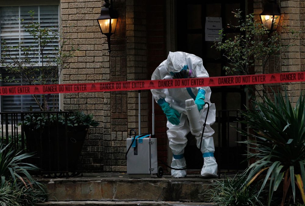 A man dressed in protective hazmat clothing treats the front porch of an apartment where a second person diagnosed with the Ebola virus resides on October 12, 2014 in Dallas, Texas.(Mike Stone/Getty Images)