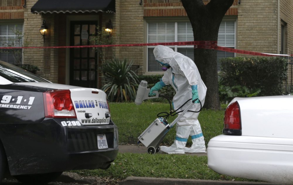 A hazmat worker cleans outside the apartment building of a hospital worker, Sunday, Oct. 12, 2014, in Dallas. (LM Otero/AP)