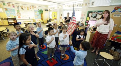 Dena Vardaxis: &quot;If we are going to ask school children to recite it daily, shouldn't we as a society have to demonstrate what it means, daily?&quot; Pictured: Children in Tacoma, Wash., start their day with the Pledge of Allegiance. (Ted Warren/AP)