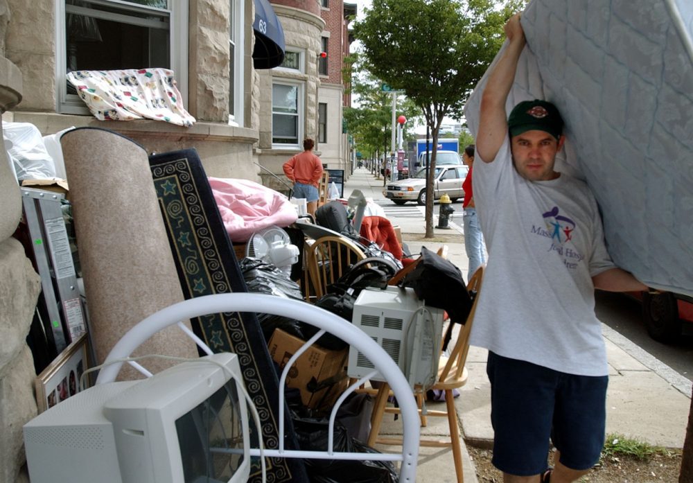 Celso Bias carries out a mattress from his apartment in Allston. (Chitose Suzuki/AP)
