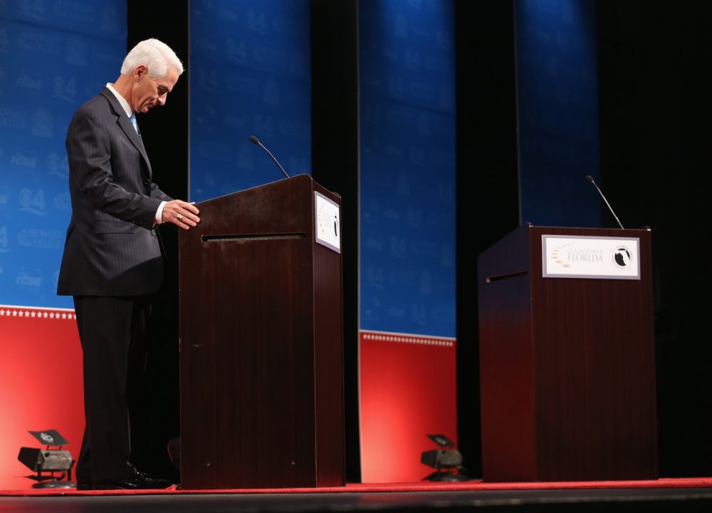 Former Florida Governor and Democratic candidate for Governor Charlie Crist waits next to an empty podium for Republican Florida Governor Rick Scott who delayed his entry onto the stage due to an electric fan that Crist had at his podium as they participate in a televised debate at Broward College on October 15, 2014 in Davie, Florida. (Joe Raedle/Getty Images)
