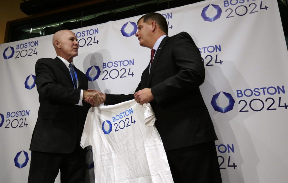 Boston Mayor Marty Walsh, right, is presented with a tee shirt by Ralph Cox, an organizer pursuing an Olympics bid, during an event held to generate public interest in a 2024 Olympics bid for Boston, Monday, Oct. 6, 2014, in Boston. (Steven Senne/AP)