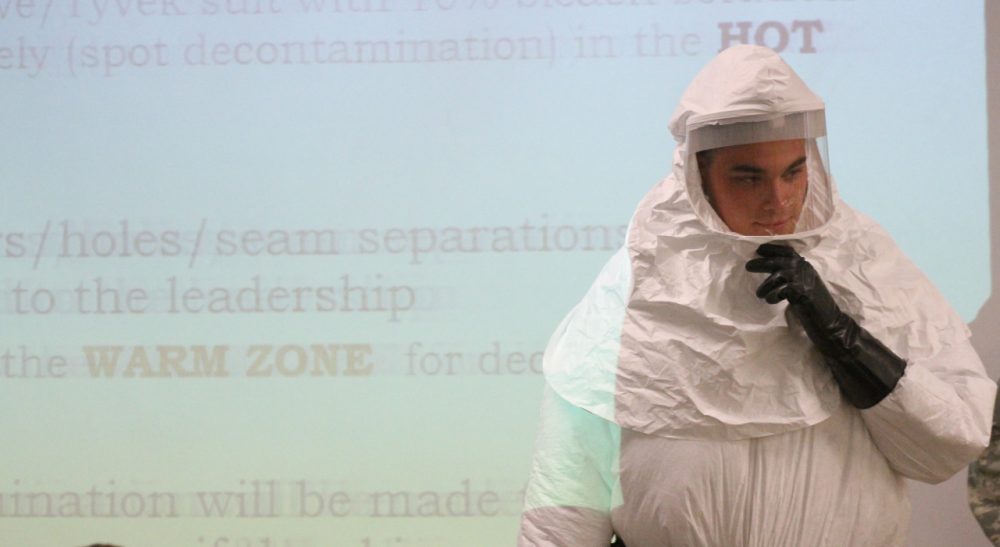 Cpl. Zachary Wicker shows the use of a germ-protective gear in Fort Bliss, Texas, Tuesday, Oct. 14,  2014. About 500 Fort Bliss soldiers are preparing for deployment to West Africa where they will provide support in a military effort to contain the Ebola outbreak. /Juan Carlos Llorca/AP)