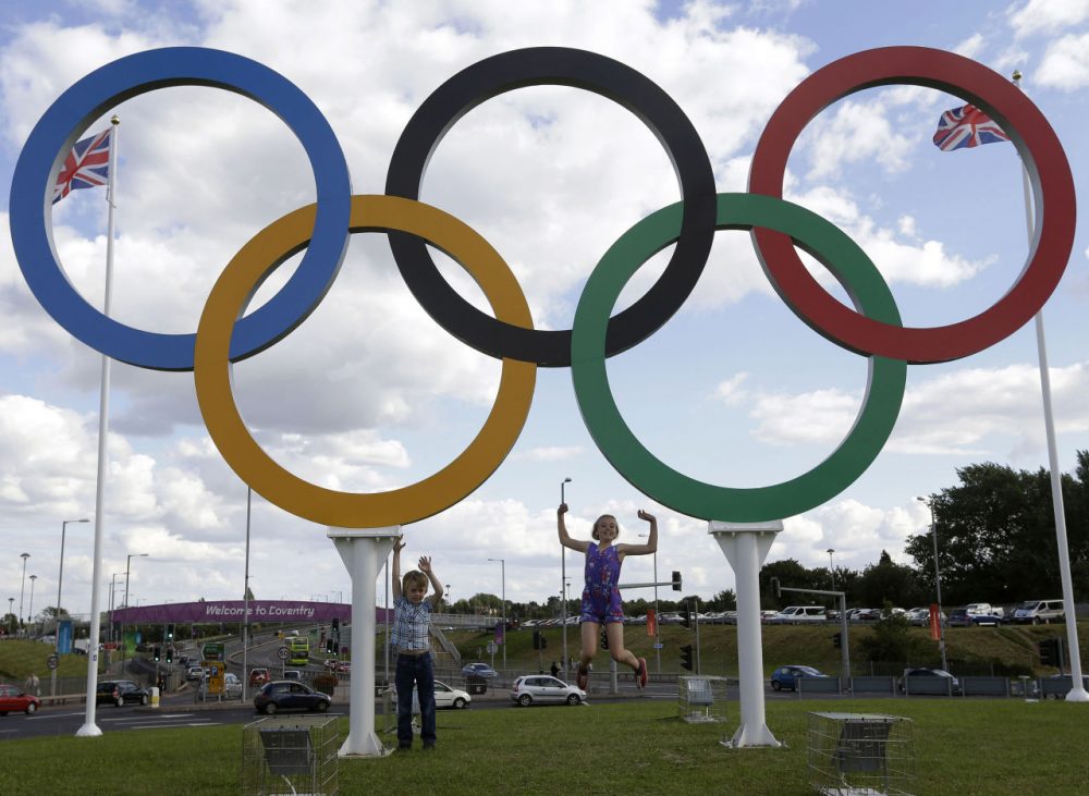 In this July 28, 2012 file photo, children posed for photos under the Olympics rings in Coventry, England. Boston, Los Angeles, San Francisco and Washington are in the running for a possible U.S. bid to host the 2024 Summer Olympics. (Hussein Malla/AP)