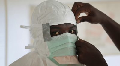 Michael Collins: The health care system that was so thoughtfully reconstructed after Liberia’s long civil wars is now once again struggling to meet the demands. In this Sept. 29, 2014, file photo a MSF (Medecins Sans Frontieres) nurse gets prepared with Personal Protection Equipment before entering a high risk zone of MSF's Ebola isolation and treatment center in Monrovia, Liberia. (Jerome Delay/AP)