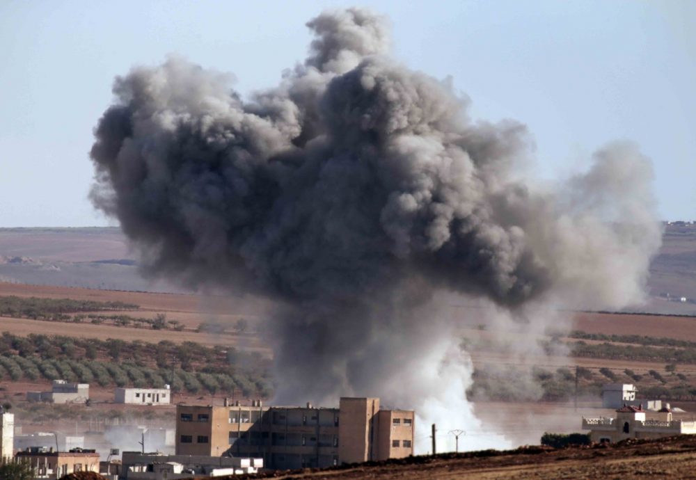 Thick smoke from an airstrike by the US-led coalition rises in Kobani, Syria, as seen from a hilltop on the outskirts of Suruc, at the Turkey-Syria border, Monday, Oct. 20, 2014 Kobani, also known as Ayn Arab, and its surrounding areas, has been under assault by extremists of the Islamic State group since mid-September and is being defended by Kurdish fighters. (AP Photo/Lefteris Pitarakis)