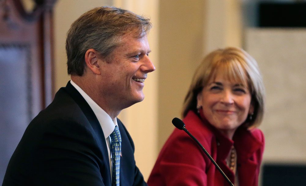 Republican nominee for governor Charlie Baker smiles as he addresses a forum in Boston on Sept. 24. At right is Democratic nominee Martha Coakley. (Charles Krupa/AP)