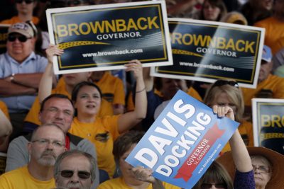 Supporters hold up campaign signs during a debate between Republican Gov. Sam Brownback and his Democratic challenger, Paul Davis, at the Kansas State Fair Saturday, Sept. 6, 2014, in Hutchinson, Kan. (AP)