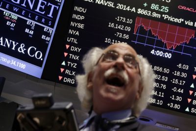 In this Wednesday, Oct. 15, 2014, file photo, trader Peter Tuchman watches a screen above the floor of the New York Stock Exchange at the closing bell, as the Dow Jones industrial average plummeted as much as 460 points in afternoon trading, then clawed back much of the ground it lost. (AP)