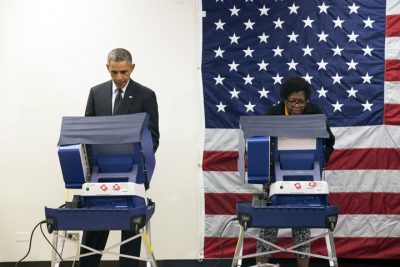resident Barack Obama, left, votes early for the midterm election at the Dr. Martin Luther King Community Service Center Monday, Oct. 20, 2014, in Chicago. Obama took a break from campaigning for Gov. Pat Quinn, D-Ill., to cast an early ballot for the election. (AP)