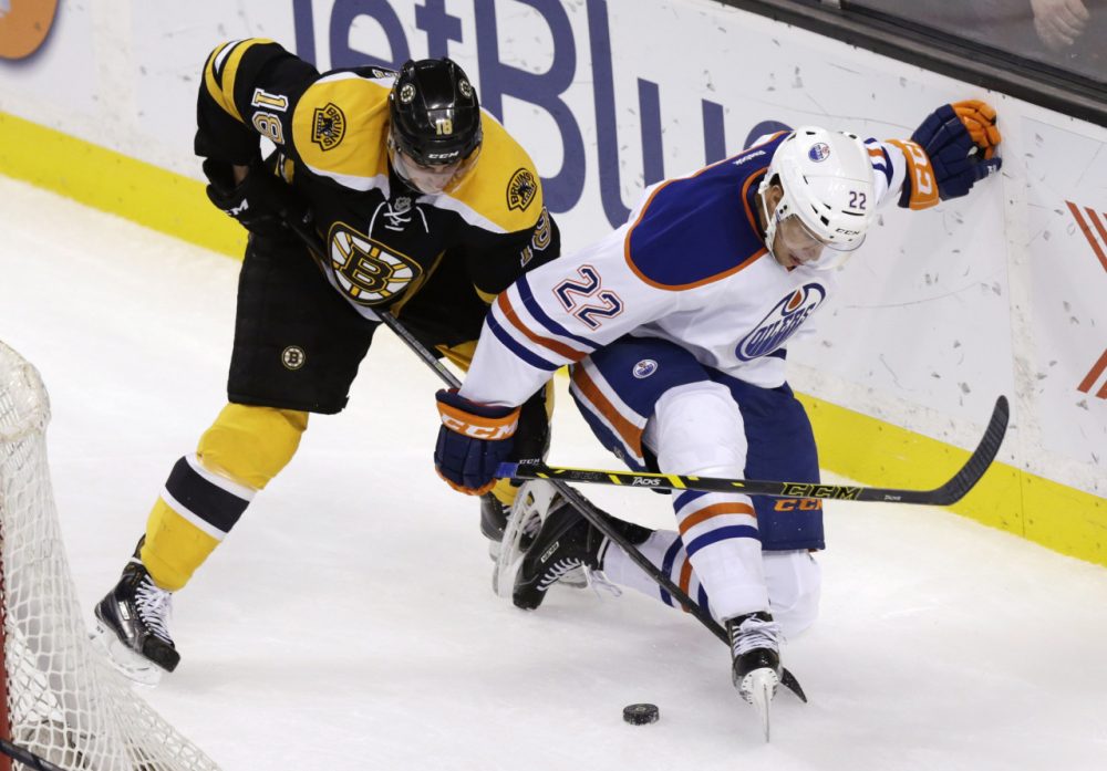 Boston Bruins right wing Reilly Smith (18) and Edmonton Oilers defenseman Keith Aulie (22) vie for the puck during the third period of an NHL hockey game Thursday. (Charles Krupa/AP)