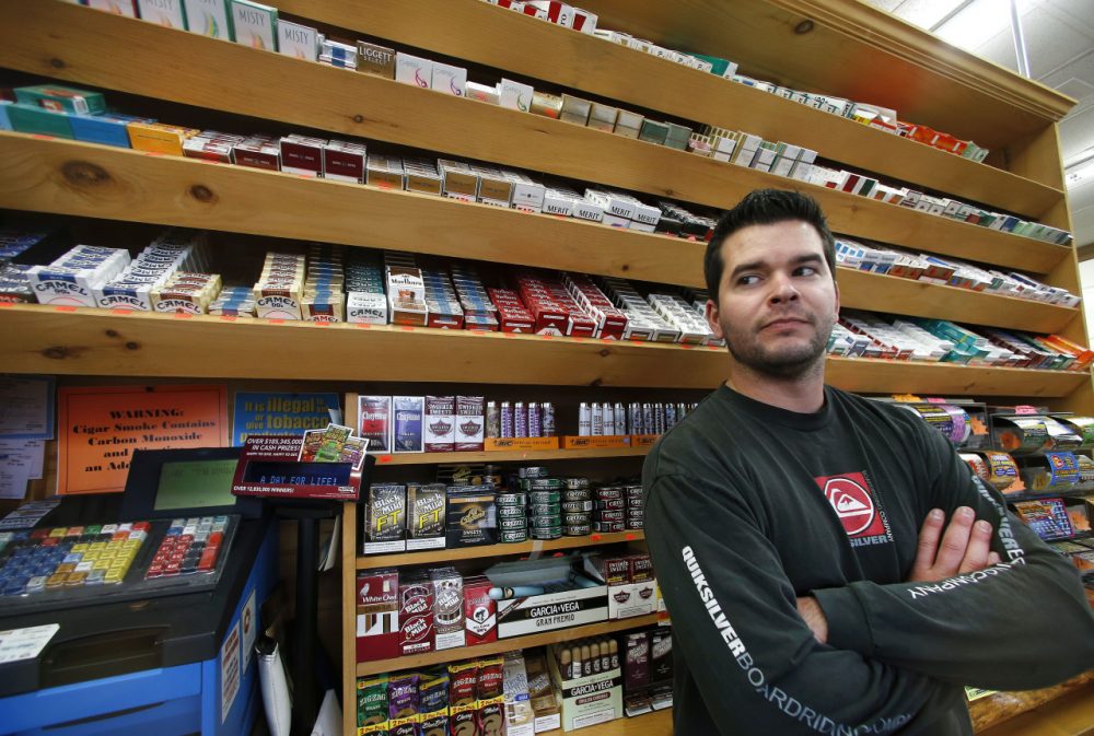 Brian Vincent poses in front of a large display of tobacco products at Vincent's Country Store in Westminster on Nov. 6. Local officials are contemplating what could be a first: a blanket ban on all forms of tobacco and e-cigarettes, leaving some shop owners fuming. (Elise Amendola/AP)