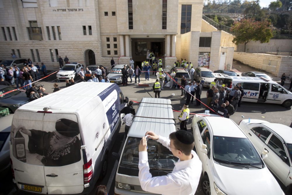 An ultra-Orthodox Jewish youth takes a picture at the scene of a shooting attack in a synagogue in Jerusalem Tuesday. (Sebastian Scheiner/AP)