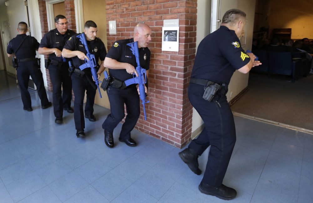Officers from the Methuen, Mass., police department carry training weapons as they search the halls of a school during a demonstration to test a new system to track gunman in schools on Nov. 11, 2014. (Charles Krupa/AP)