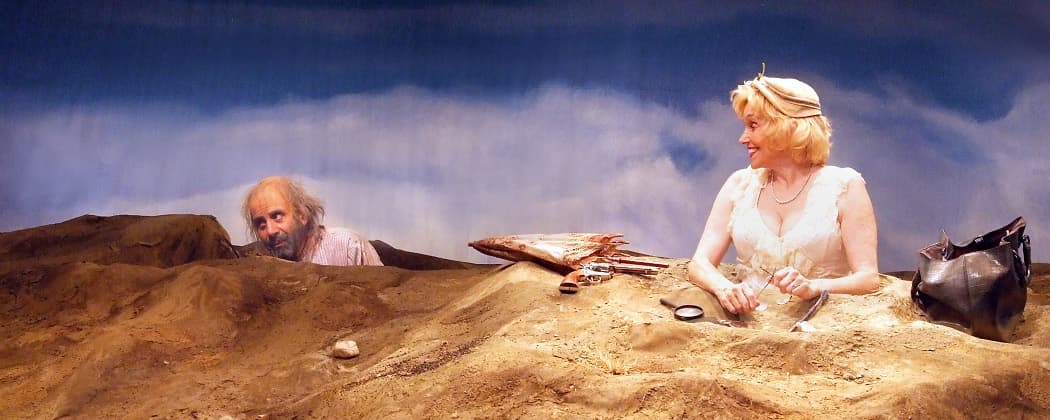 This reexamination of the Samuel Beckett's &quot;Happy Days&quot; features Brooke Adams as Winnie, a woman buried up to her bosom in a mound of dirt, and her husband Willie, (Tony Shalhoub), lurking somewhere behind her. (Courtesy Ed Krieger)