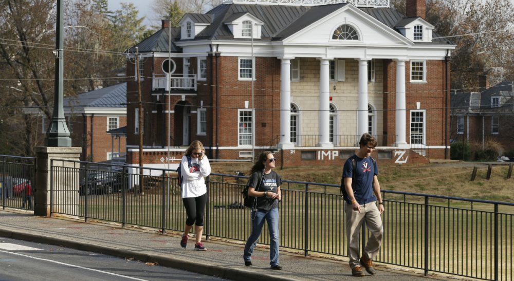 In this photo, University of Virginia students walk to campus past the Phi Kappa Psi fraternity house at the University of Virginia in Charlottesville, Va. Rolling Stone is casting doubt on the account it published of a young woman who says she was gang-raped at a Phi Kappa Psi fraternity party at the school, saying there now appear to be discrepancies in the student's account. (Steve Helber/AP)