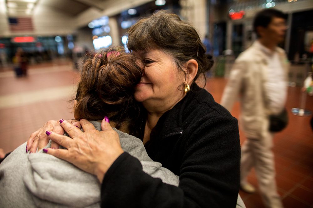 Lisette, left, is seeking asylum in the U.S. She fled El Salvador, with a daughter, on July 12, and arrived at Boston's South Station, where she was embraced by her aunt, on Oct. 7. (Jesse Costa/WBUR)