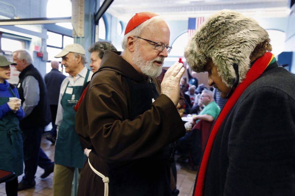 Archbishop of Boston Sean O'Malley administers a blessing while serving meals at the Pine Street Inn homeless shelter in Boston  Wednesday. (Michael Dwyer/AP)