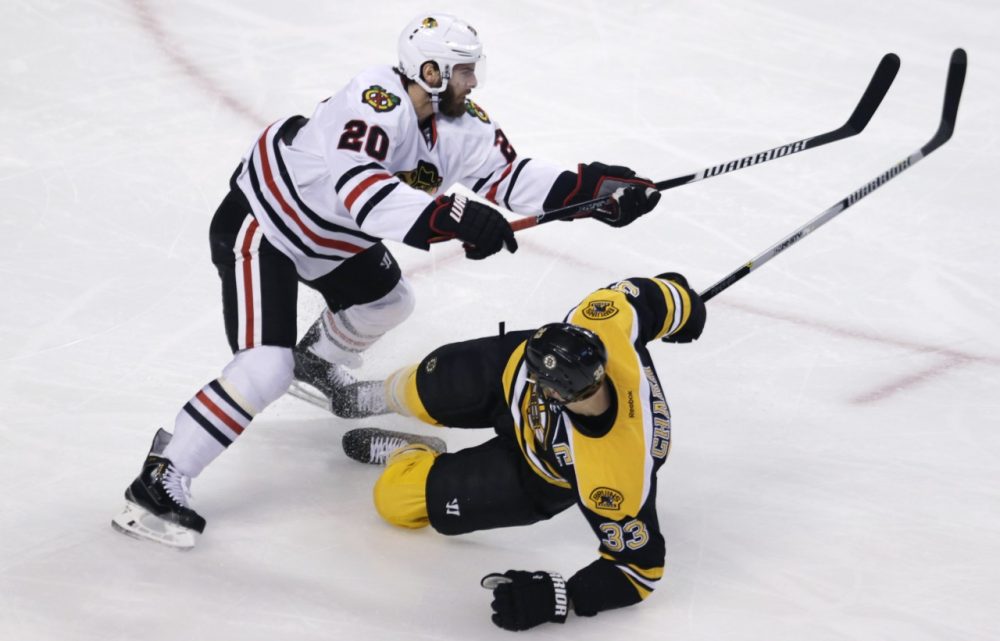 Chicago Blackhawks left wing Brandon Saad (20) drops Boston Bruins defenseman Zdeno Chara to the ice during the first period of Thursday, Dec. 11, 2014 game in Boston. Chara has been sidelined since October with a left knee injury. (Charles Krupa/AP)