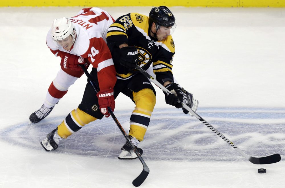 Boston Bruins left wing Brad Marchand (63) skates around Detroit Red Wings center Gustav Nyquist (14)  in Boston, Monday, Dec. 29, 2014. (Charles Krupa/AP)