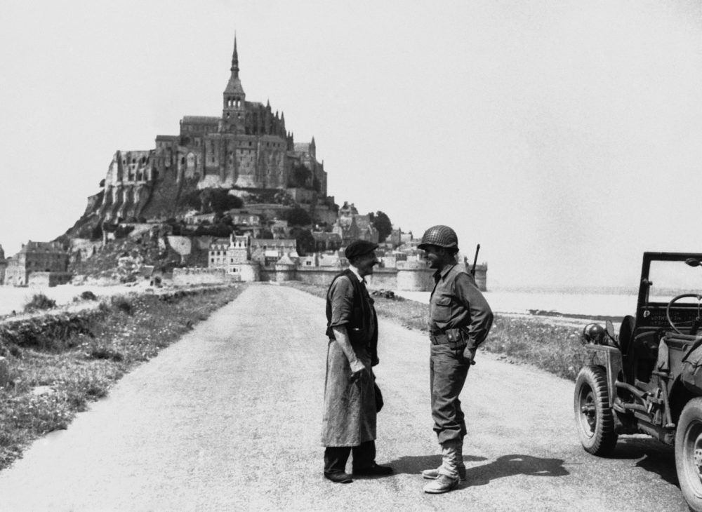 An American soldier and a French civilian chat on the causeway leading from the mainland of Brittany to the famous tourist resort of Mont St. Michel in Normandy on August 8, 1944. American forces in their advance across the peninsula seized the resort, which was undamaged. (HH/AP)