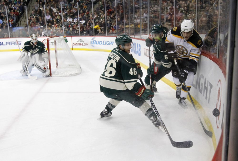 Boston Bruins left wing Milan Lucic, right, and Minnesota Wild defensemen Marco Scandella (6) and Jared Spurgeon (46) compete for the puck during last night's game in St. Paul, Minn., Wednesday, Dec. 17, 2014. The Bruins won 3-2 in overtime. (Ann Heisenfelt/AP)