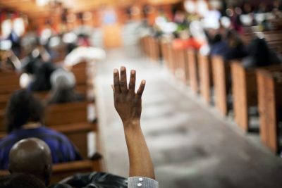 Morma Francis, of Atlanta, raises her hand to ask a question during a community town hall forum at Ebenezer Baptist Church, the church where The Rev. Martin Luther King Jr. preached, Monday, Dec. 8, 2014, in Atlanta. (AP)