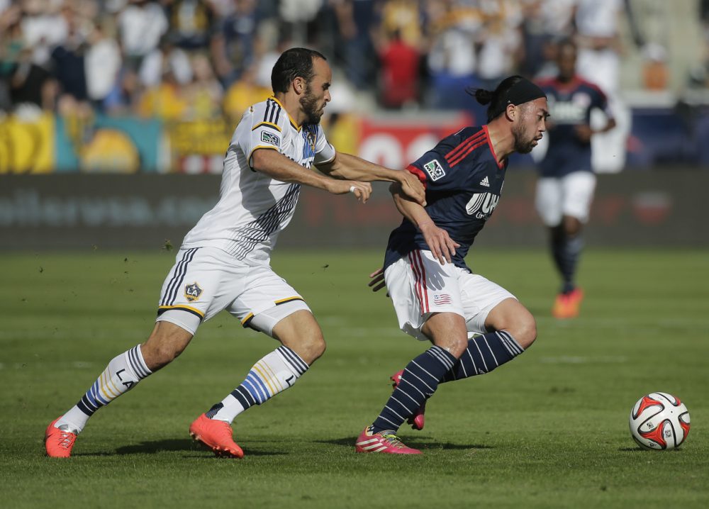 Los Angeles Galaxy's Landon Donovan, left, grabs the arm of New England Revolution's Lee Nguyen during the first half of the MLS Cup championship soccer match Sunday. (Jae C. Hong/AP)