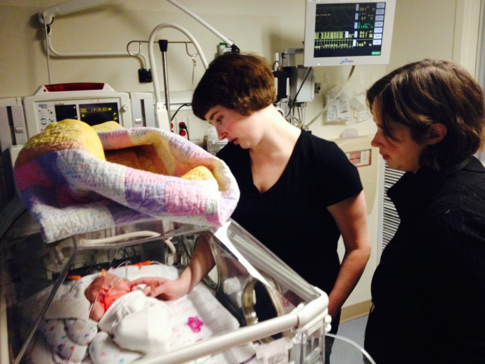 Jen (left) and Mel Turner with young Margaret in the NICU. (Zack Ezor/WBUR)