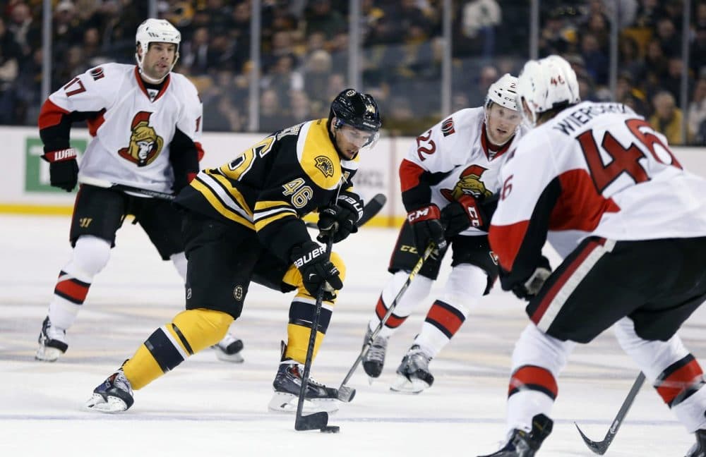 Boston Bruins' David Krejci (46), of the Czech Republic, brings the puck up as Ottawa Senators' Patrick Wiercioch (46) and Erik Condra (22) defend during the second period of an NHL hockey game in Boston. (Michael Dwyer/AP)