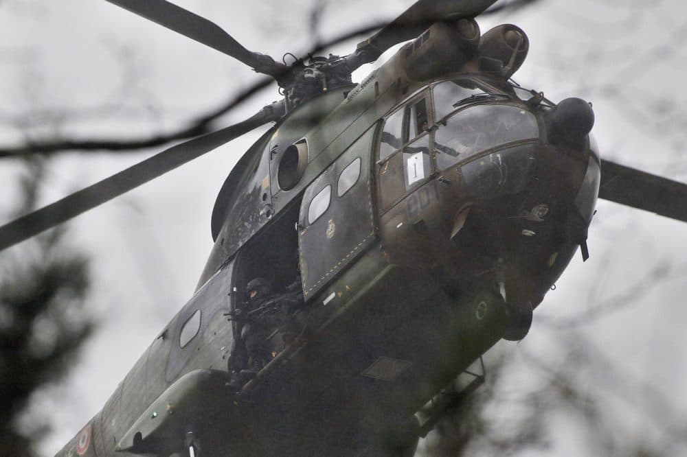 Armed security forces fly in a military helicopter in Dammartin-en-Goele on Friday. French security forces swarmed this small industrial town northeast of Paris in an operation to capture a pair of heavily armed suspects in the deadly storming of a satirical newspaper. (Thibault Camus/AP)