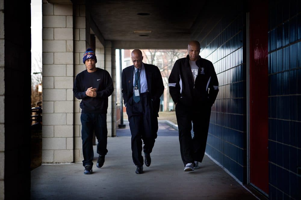 Alex DoSouto, left, Dr. Charles Diggs, dean of Enrollment at Roxbury Community College, center, and Anthony “Big Time” Seymour, violence interrupter for the Boston Center for Youth and Families, walk to the registration office at RCC last year. (Jesse Costa/WBUR)