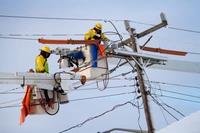 Workers from Western Mass Electric repair downed powerlines in Marshfield. (Jesse Costa/WBUR)
