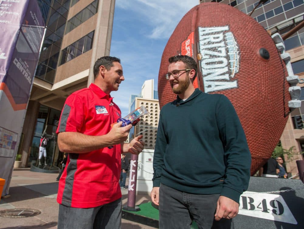 Chicago Bears kicker Jay Feely hands over Super Bowl XLIX tickets to Kyle Porter after winning the #SB49 Scavenger Hunt on Wednesday in Phoenix. (Jeff Lewis/AP)