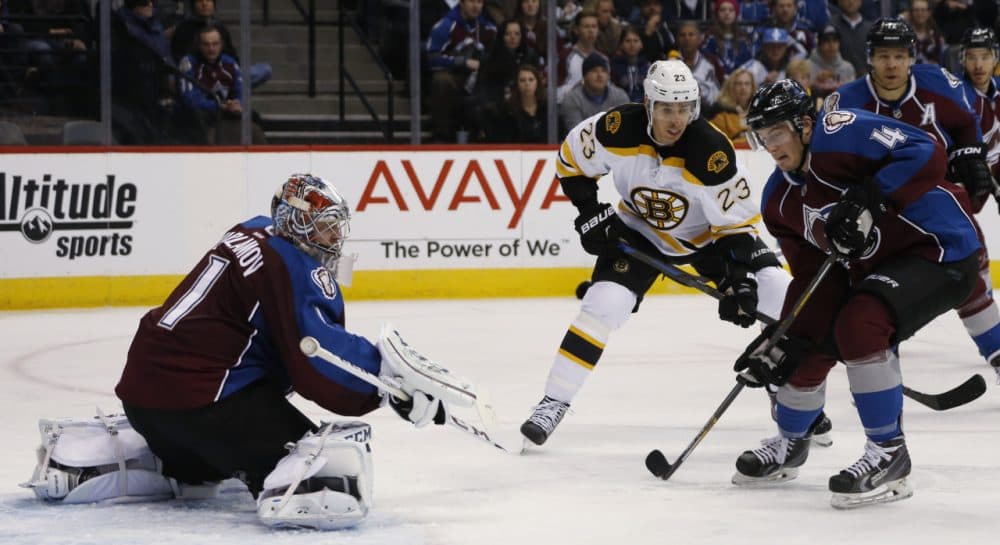 Colorado Avalanche defenseman Tyson Barrie, front right, clears the puck after a shot off the stick of Boston Bruins center Chris Kellyu, back right, was stopped by Avalanche goalie Semyon Varlamov, of Russia, during Wednesday night's game on Jan. 21, 2015, in Denver. (David Zalubowski/AP)