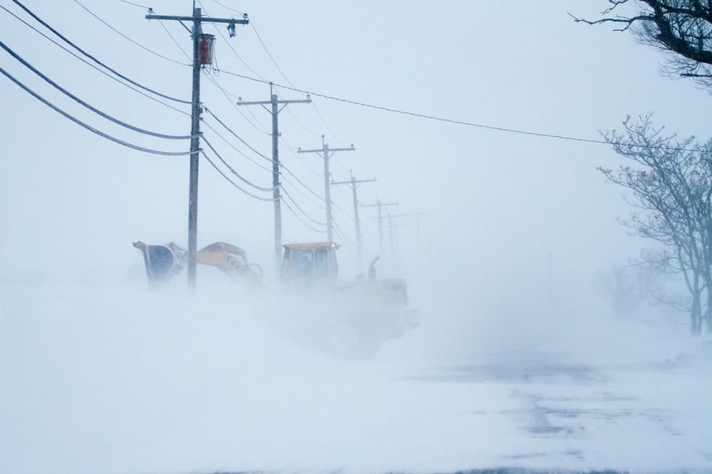 A land mover battles high winds moving snow off of the Plum Island Turnpike at Plum Island, in 2015. (Jesse Costa/WBUR/File)