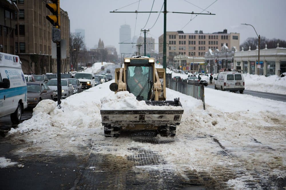 The Massachusetts National Guard 379th Engineering Company clears snow from the Green Line at the intersection of Commonwealth Avenue and St. Paul Street in Boston on Tuesday afternoon. (Jesse Costa/WBUR)