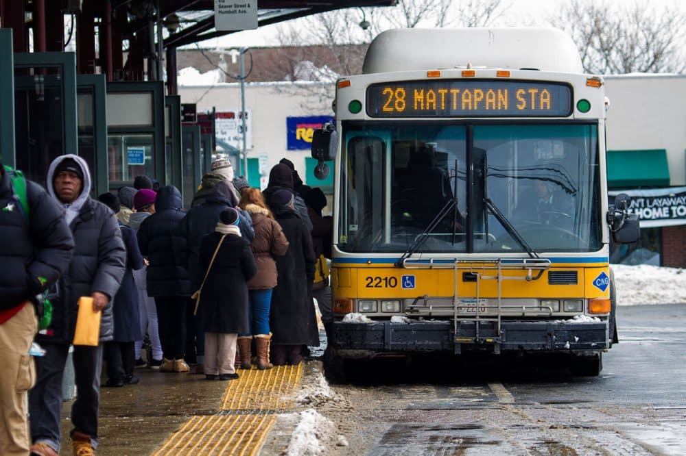 As the MBTA considers  two fare hike proposals, many opponents say increases to the cost of a monthly bus pass would burden many residents. Pictured: Commuters board the #28 Mattapan Station bus at Dudley Square MBTA station on Feb. 18, 2015. (Jesse Costa/WBUR)