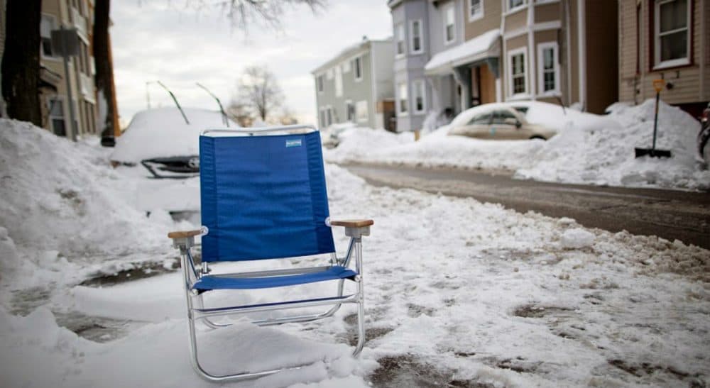 To save, or not to save your shoveled out parking spot? The answer to that question reveals more about us than we may realize. In this photo, a blue beach chair marks a parking space on I St. in South Boston, Jan. 28, 2015. (Robin Lubbock/WBUR)