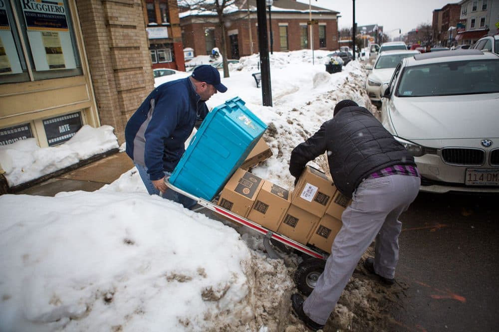 Anthony Dimare, left, loses the items he is delivering in February in East Boston. (Jesse Costa/WBUR)