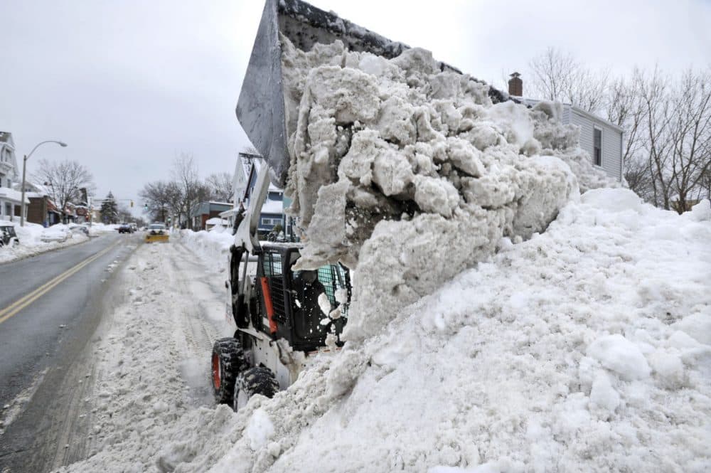 Near Davis Square in Somerville Tuesday, crews worked to remove snow from city streets. (Josh Reynolds/AP)