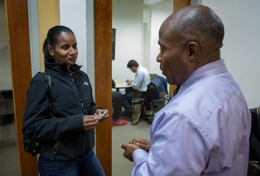 Pamela Monteiro, of Dorchester, talks with Alan Gentle, program director of the Roxbury Center for Financial Empowerment, in Dudley Square. Monteiro wants to start her own catering business. (Robin Lubbock/WBUR)