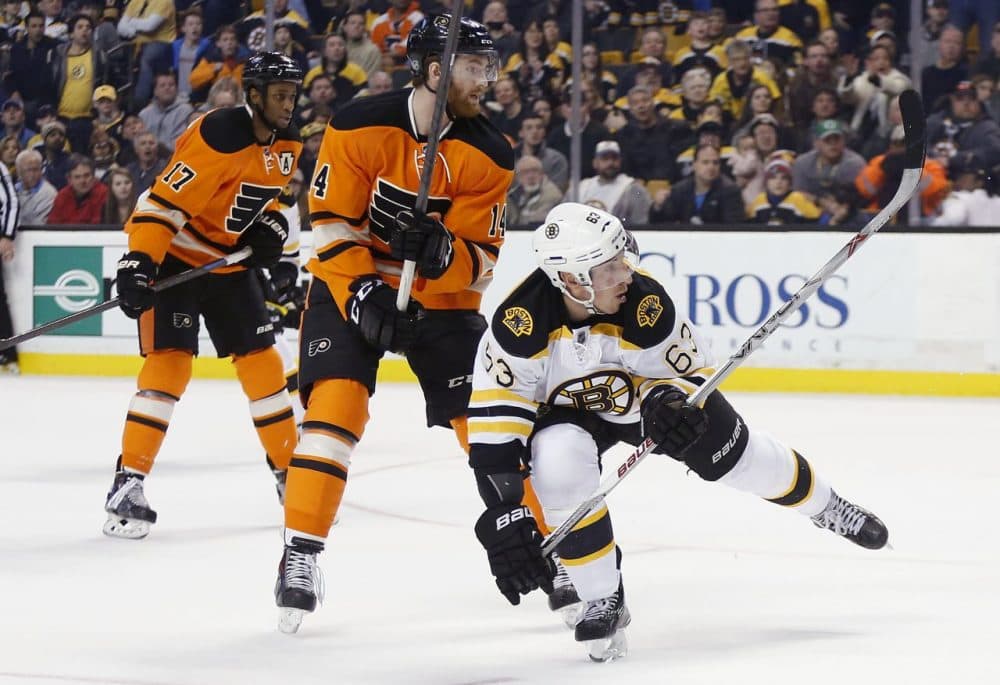 Boston Bruins' Brad Marchand (63) watches his game-winning goal in front of Philadelphia Flyers' Sean Couturier (14) and Wayne Simmonds (17). (Michael Dwyer/AP)