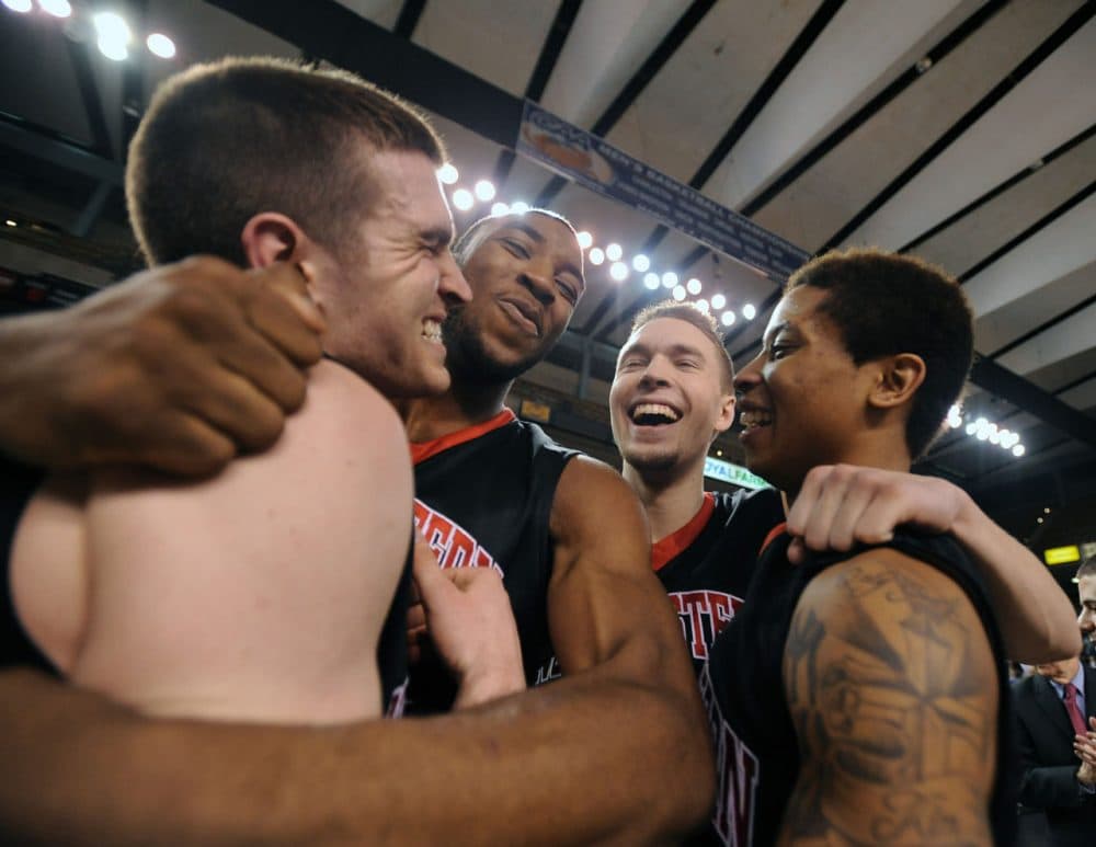 Northeastern celebrates after topping William &amp; Mary Monday night in the CAA tournament championship game. The Huskies are in the Big Dance for the first time since 1991. (Caleb Donnelly/AP)