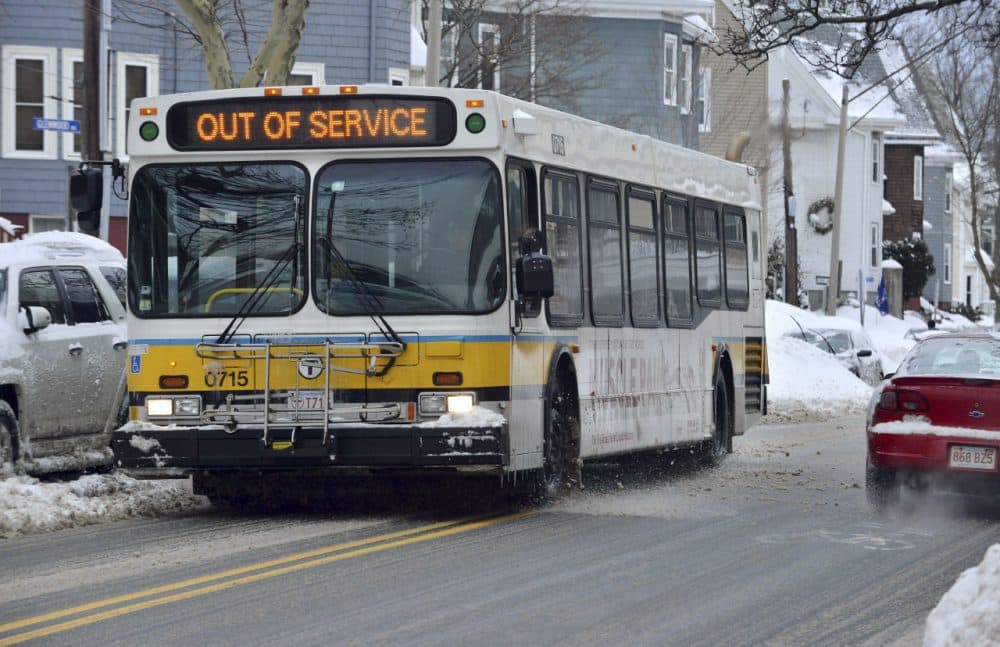 An out-of-service MBTA bus rolls through Somerville after several snowstorms in February. (Josh Reynolds/AP)