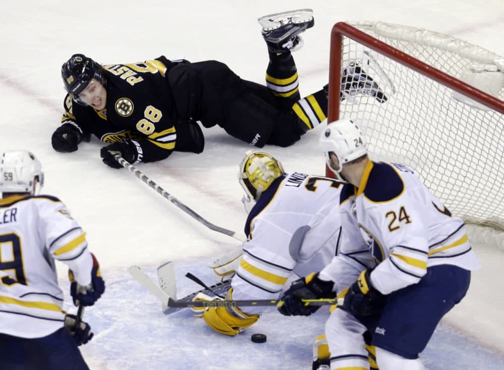Boston Bruins right wing David Pastrnak (88) tries to reach in for the puck but Buffalo Sabres goalie Anders Lindback (35) is there to keep him from scoring as Buffalo Sabres defenseman Tyson Strachan (24) looks on during the third period of an NHL hockey game in Boston, Tuesday. (Elise Amendola/AP)