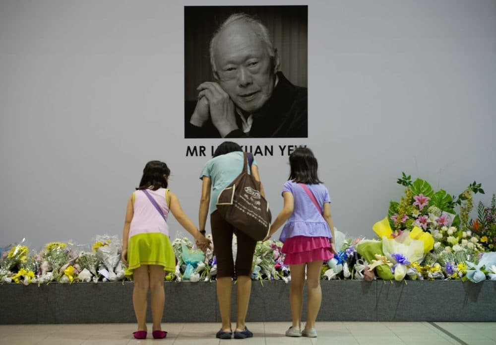 Singaporeans pray in front of an image of late former prime minister Lee Kuan Yew alongside messages and flowers left at the Tanjong Pagar community center following Lee's death in Singapore on March 23, 2015. (Mohd Rasfan/AFP/Getty Images)