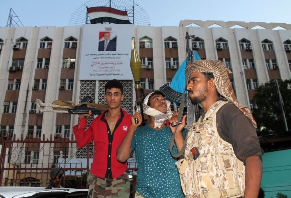 Heavily armed Yemeni fighters loyal to Yemeni President Abedrabbo Mansour Hadi (portrait on the poster) stand guard in front of the governorate building on March 18, 2015, in the southern city of Aden. Security in Aden resembles a time-bomb as forces loyal to Hadi, and others opposing him, share control over the southern city that shelters the embattled leader.  (AFP/Getty Images)