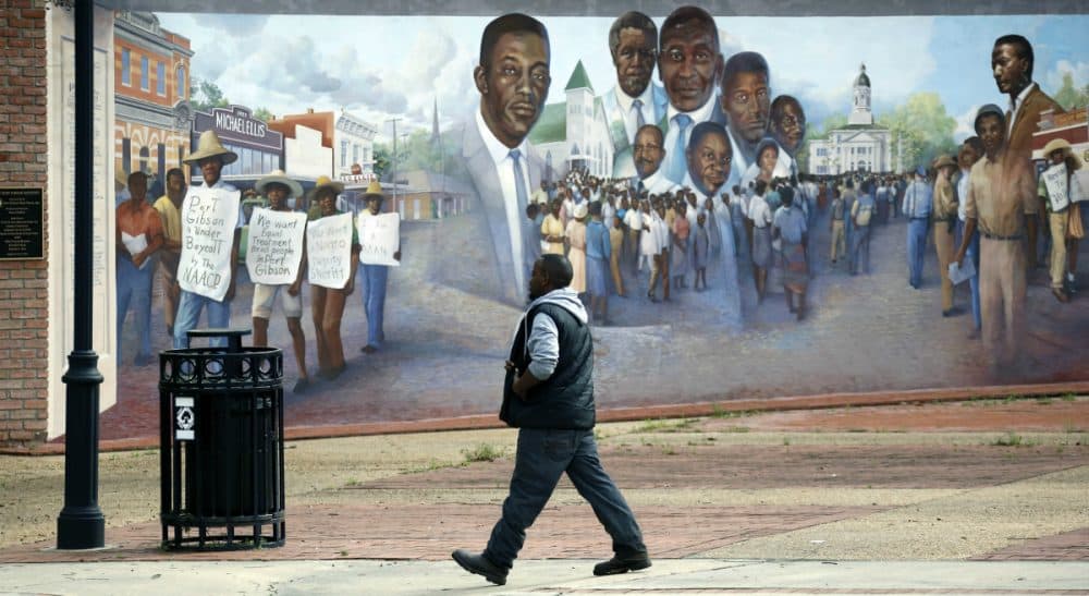 A Port Gibson, Miss., resident walks past a mural depicting a successful economic boycott protest in the 1960's, Monday, March 23, 2015. A small group of residents and friends gathered nearby to show support for the Otis Byrd's family and to call on federal and state authorities to do a thorough investigation into his death. Byrd's body was found last Thursday, hanging from a sheet from a tree in a rural area outside of Port Gibson. The FBI is consulting with its behavioral analysis unit as it continues investigating the hanging death of Byrd. (Rogelio V. Solis/AP)